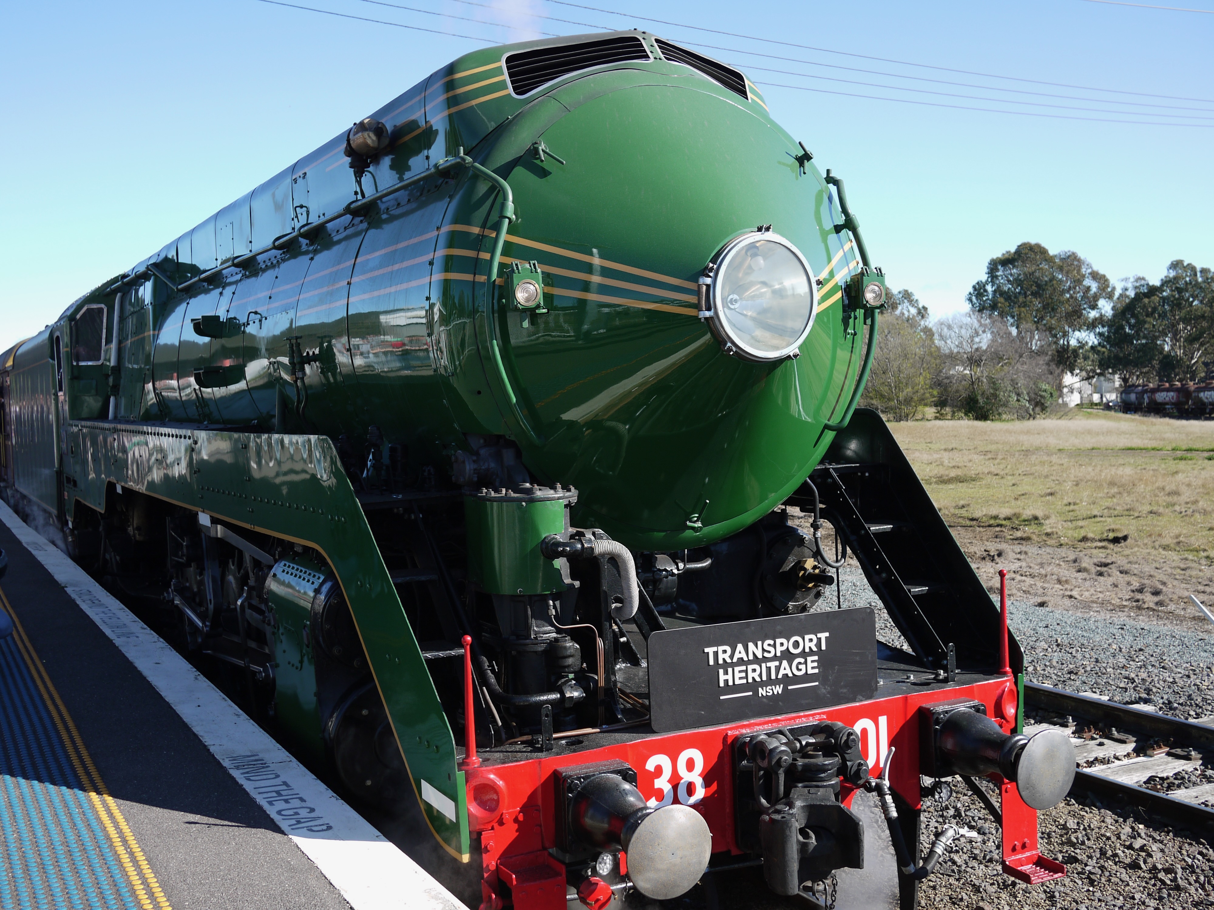 A green steam locomotive from the front on a train platform