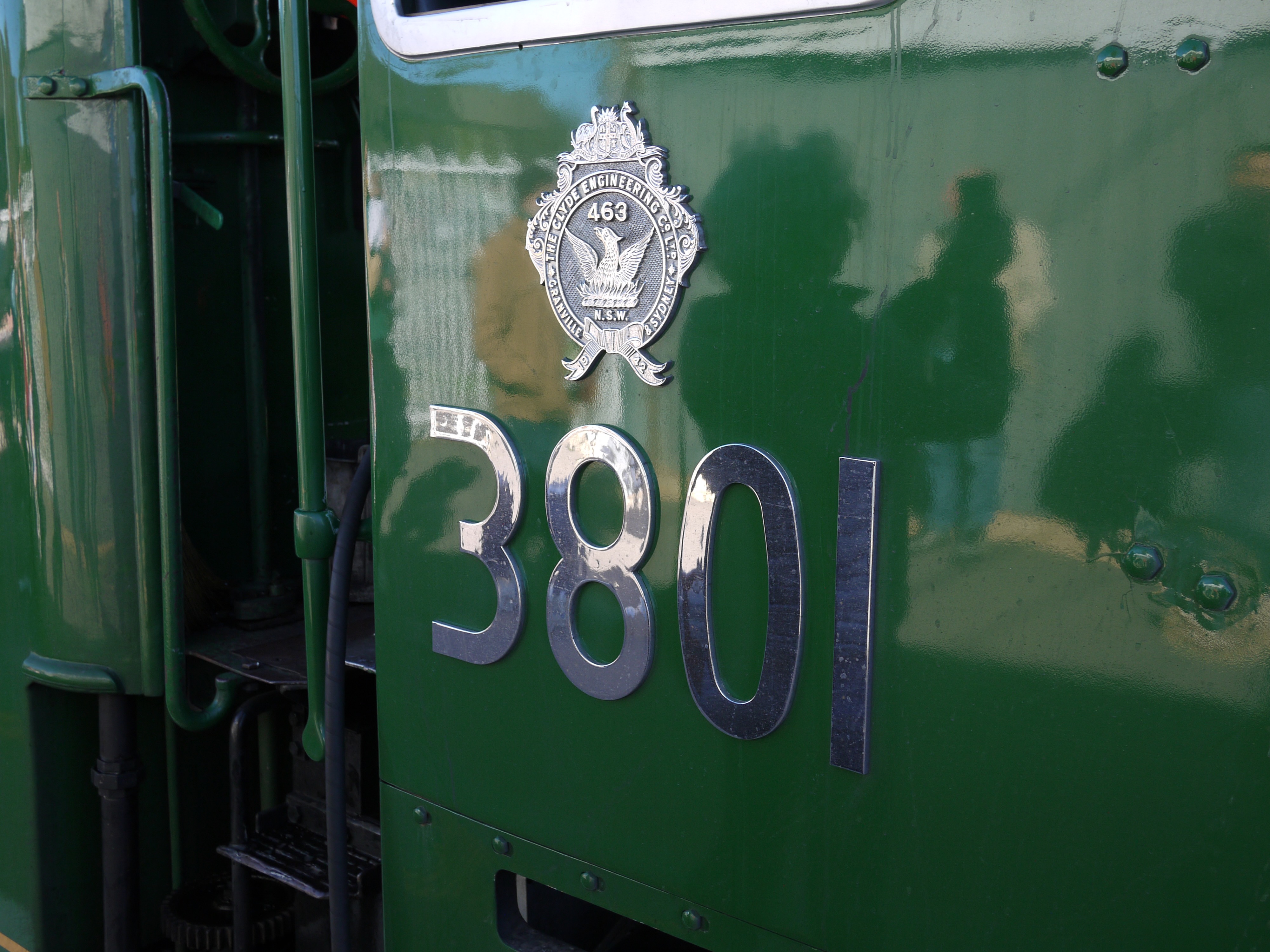 The side of a steam locomotive with shiny 3801 numbers and a shield of some description